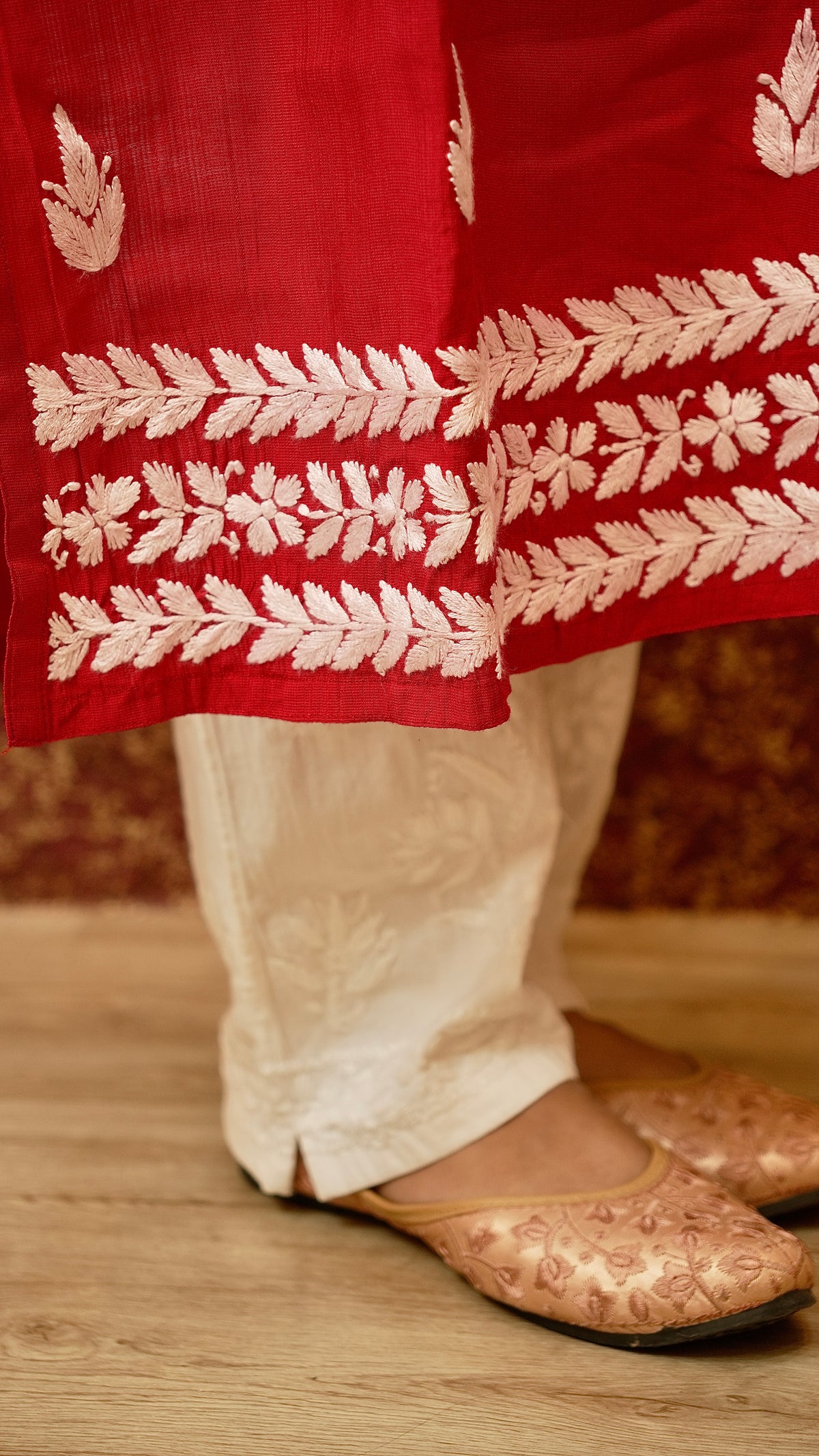 Close-up of kurti hem with traditional embroidery over cotton lycra pants. View Chikankari cotton pants.