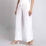 White wide-leg pants worn by a person on a gray background