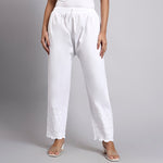 White pants worn by a person on a gray background