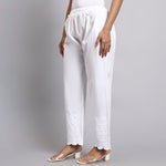 White pants worn by a person on a gray background