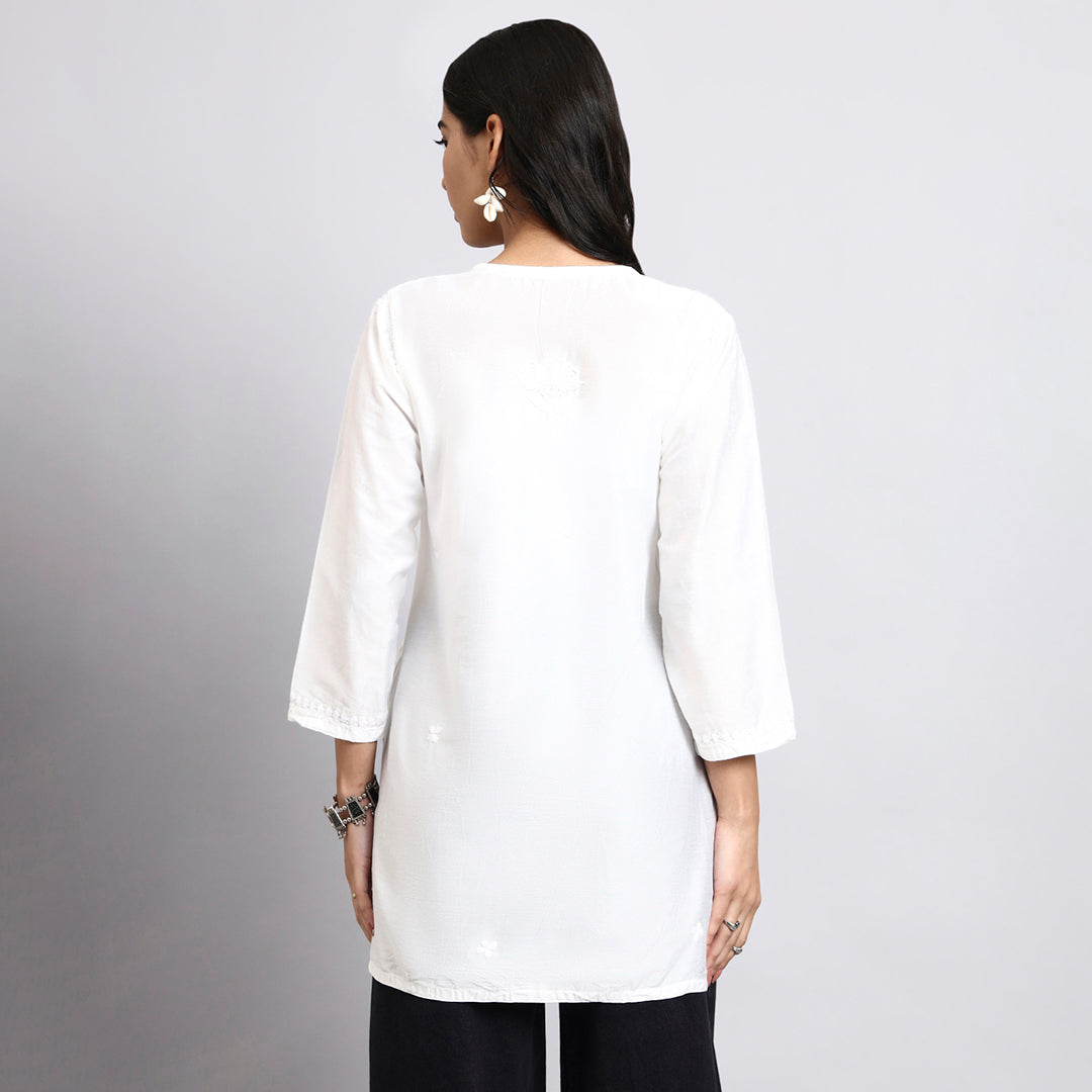 Women wearing a white long-sleeve top against a gray background.