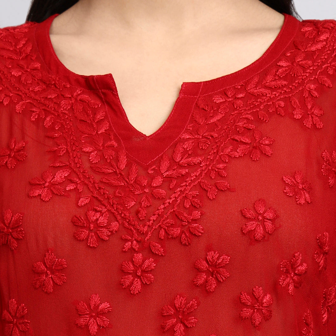 Zoom view of Red embroidered top with floral patterns on a plain background