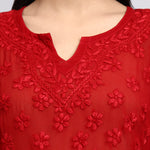 Zoom view of Red embroidered top with floral patterns on a plain background