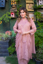 A full shot shows a woman in a mauve pink kurta that has embroidery with matching pants.