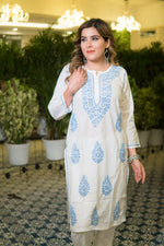 Front-angled view of a white georgette chikankari kurta focusing on the neckline and blue embroidery.