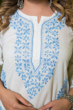 Partial side view of a white embroidered chikankari kurta highlighting fabric texture and design.