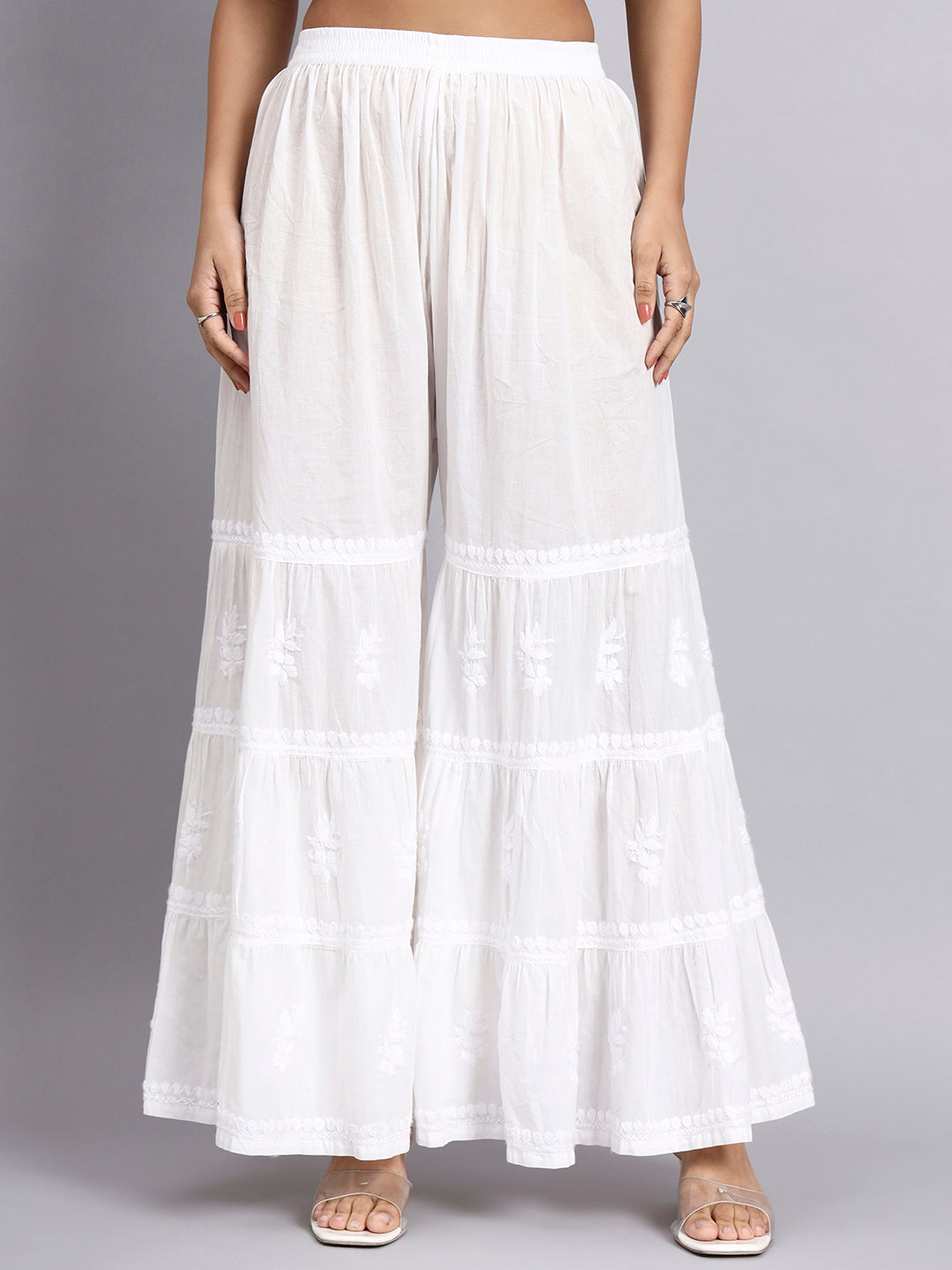 White tiered skirt worn by a person on a gray background