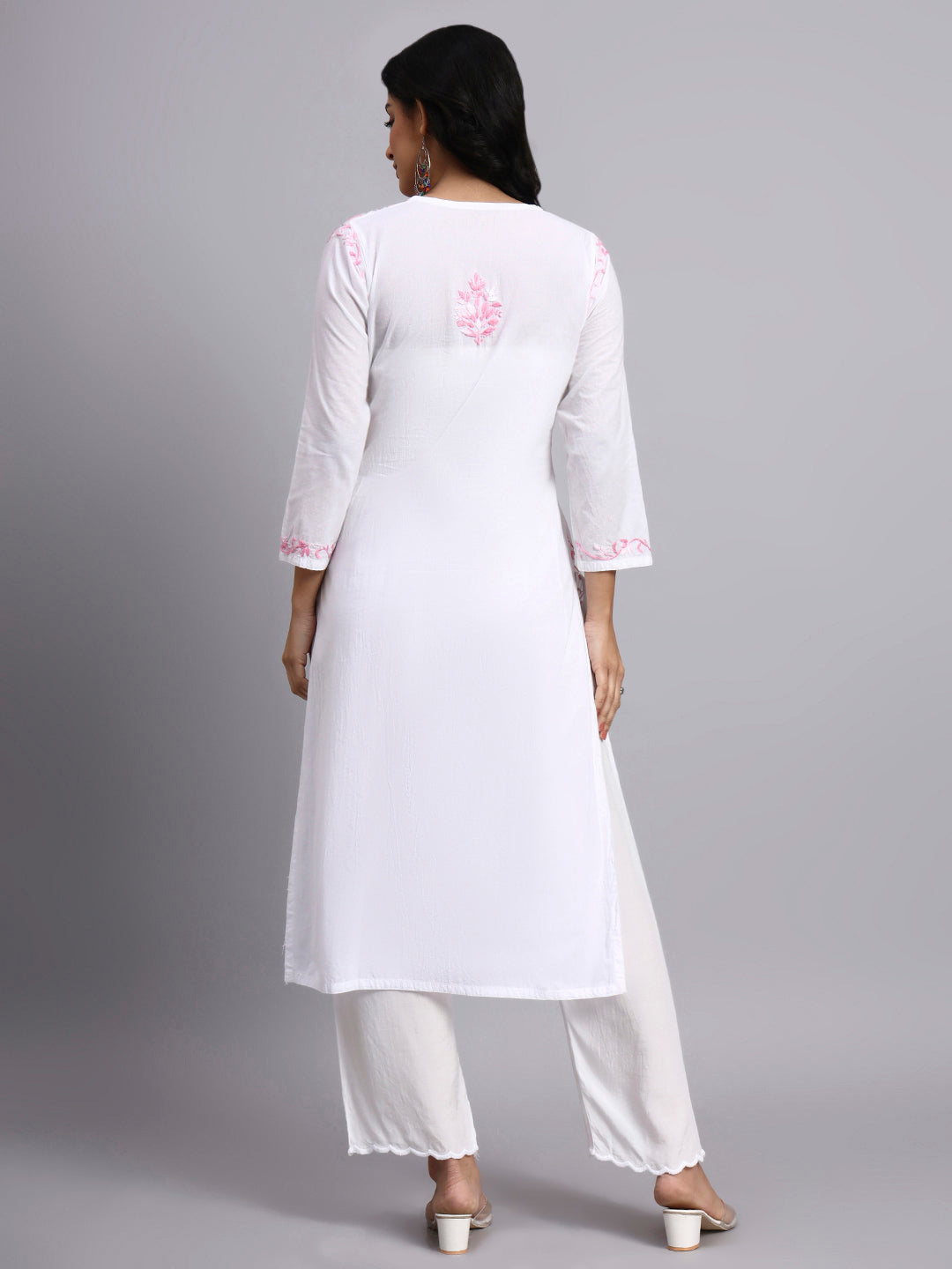 Back view of Woman wearing a white chikankari kurta with pink embroidery on a gray background