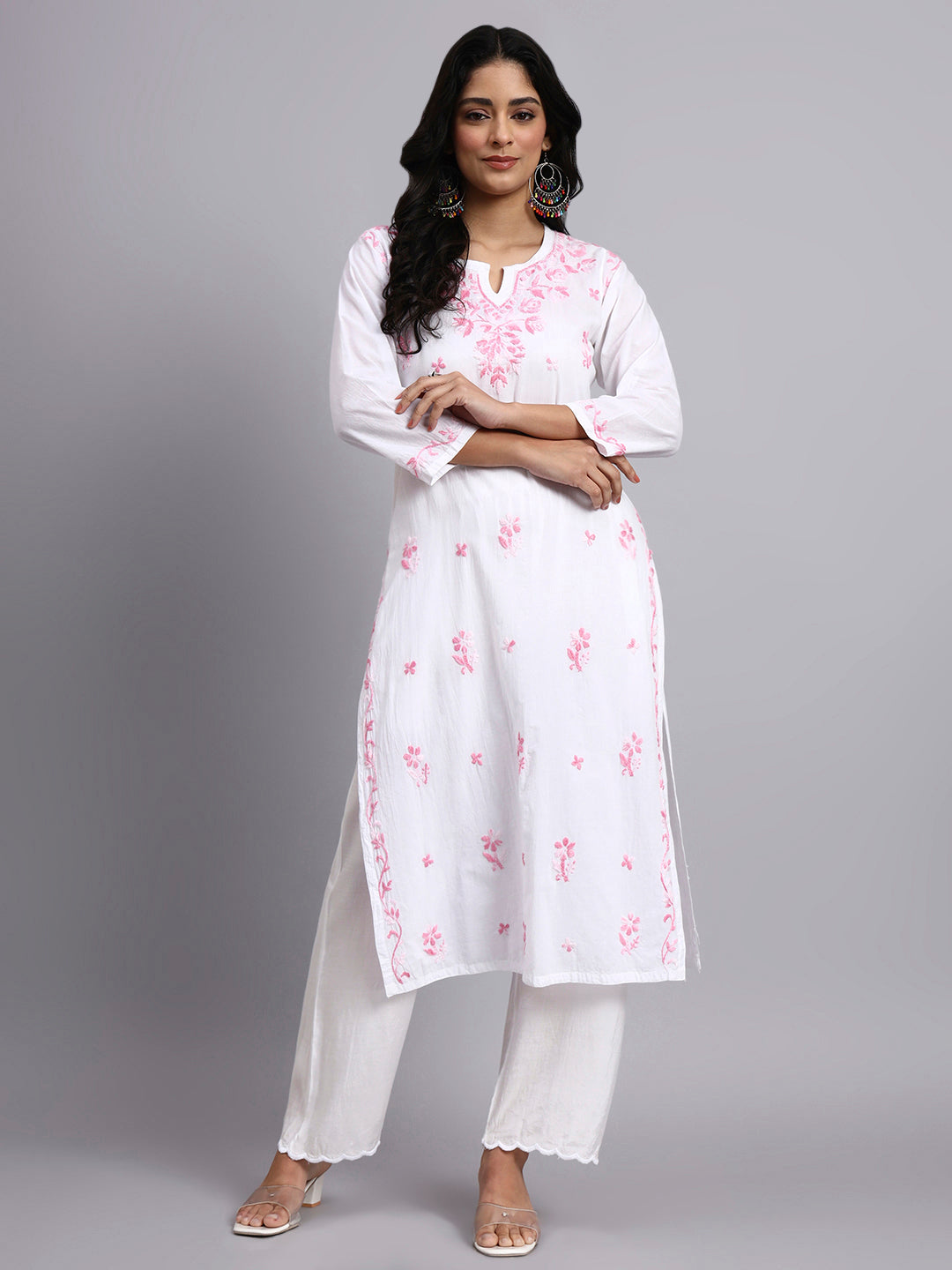 Full view of Woman wearing a white kurta with pink floral patterns on a gray background