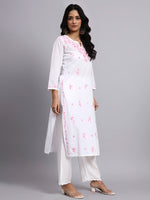 Woman wearing a white kurta with pink floral embroidery on a gray background