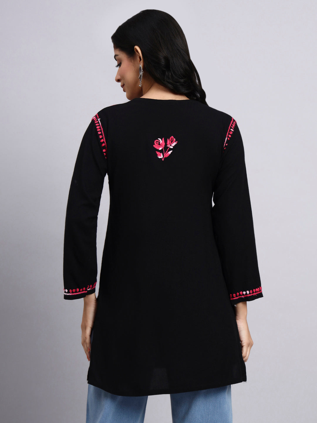 Back view of Black kurta with pink floral embroidery on a gray background
