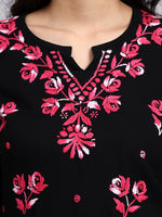 Close up view of Black garment with pink floral embroidery