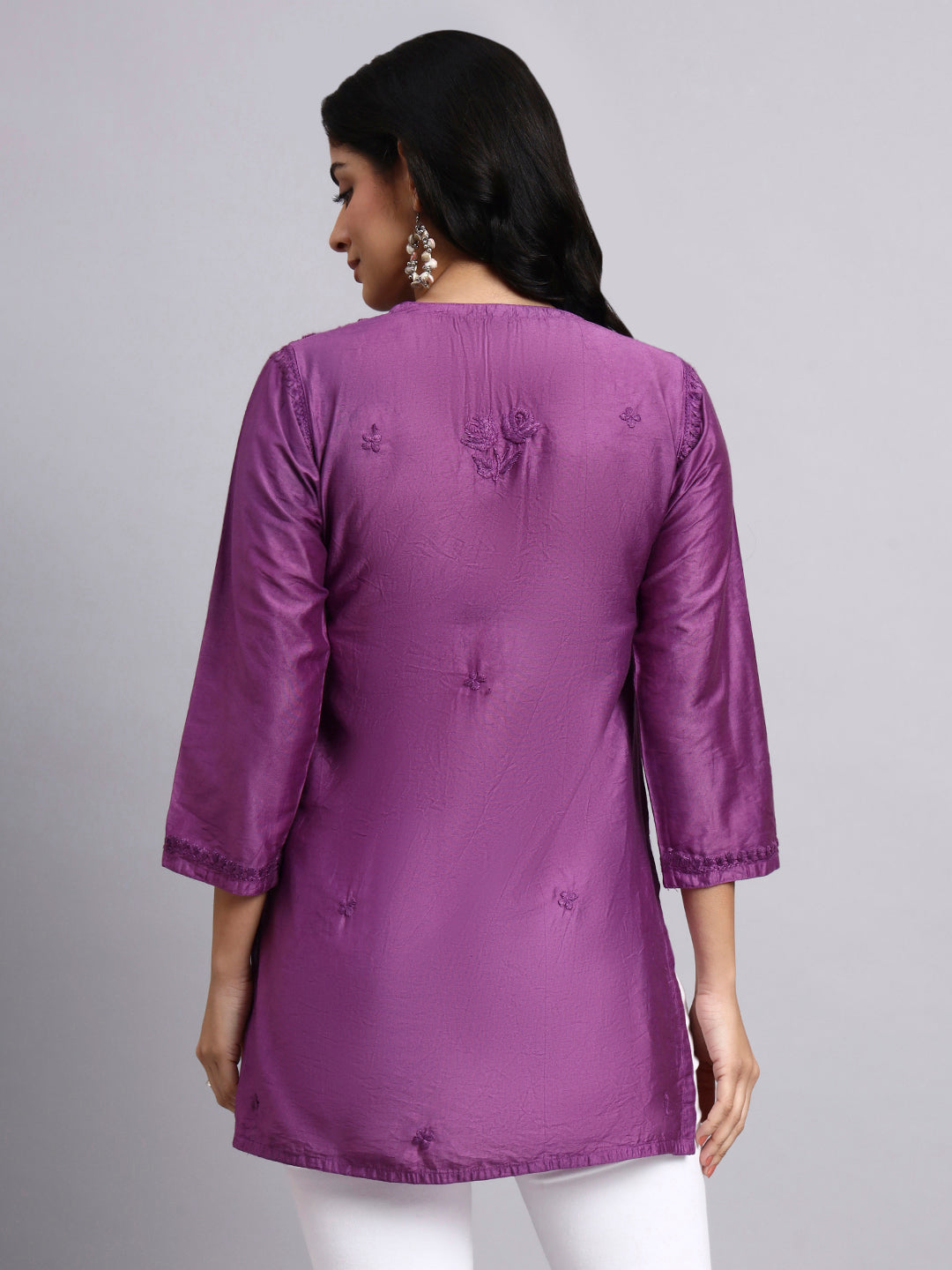 Back view of Woman wearing a purple kurta with a plain background