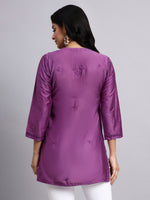 Back view of Woman wearing a purple kurta with a plain background
