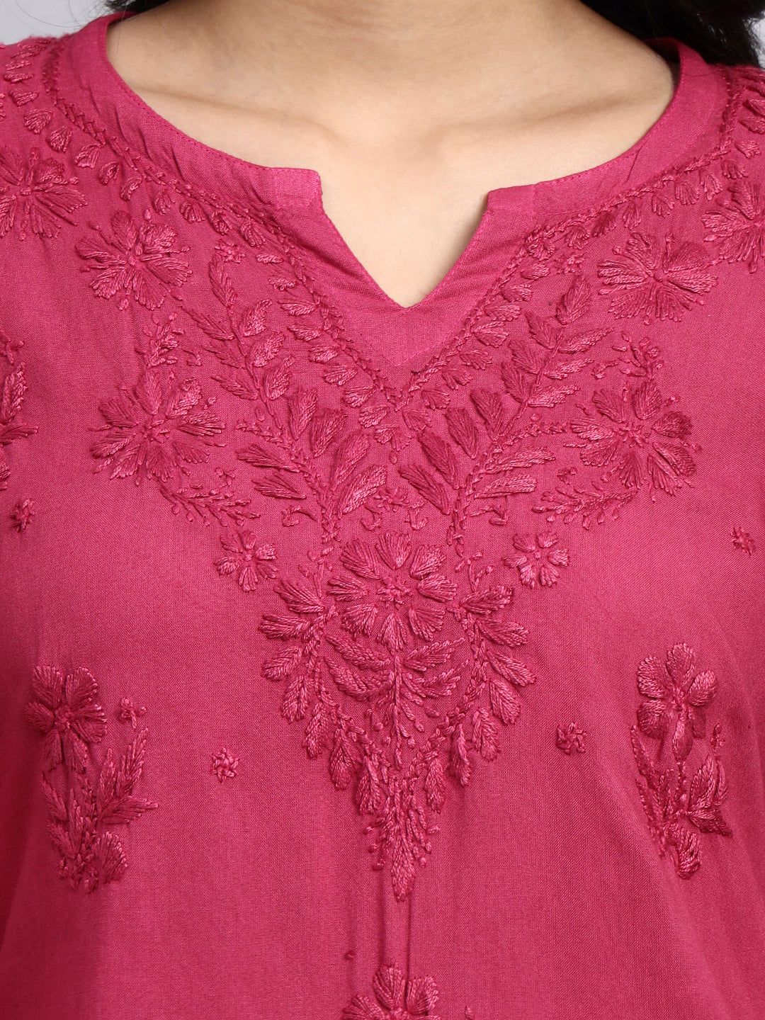 Close-up of a pink embroidered garment with intricate designs.
