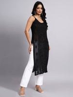Woman wearing a black sleeveless kurti and white pants on a gray background