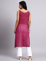 Back view of Woman wearing a rani pink sleeveless top with white pants on a gray background