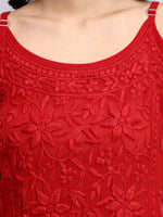 Close up view of Red lace top with intricate patterns on a plain background