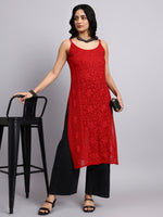 Woman wearing a red sleeveless kurta and black pants against a gray background