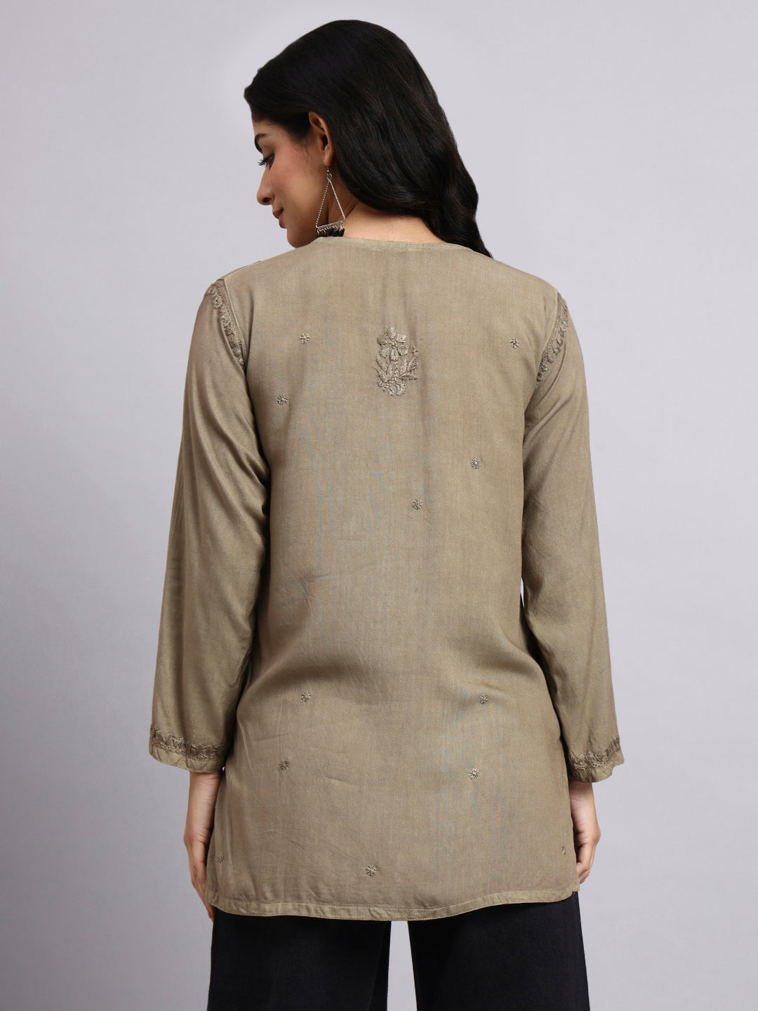 Back view of Woman wearing a olive long-sleeve top with subtle patterns on a plain background