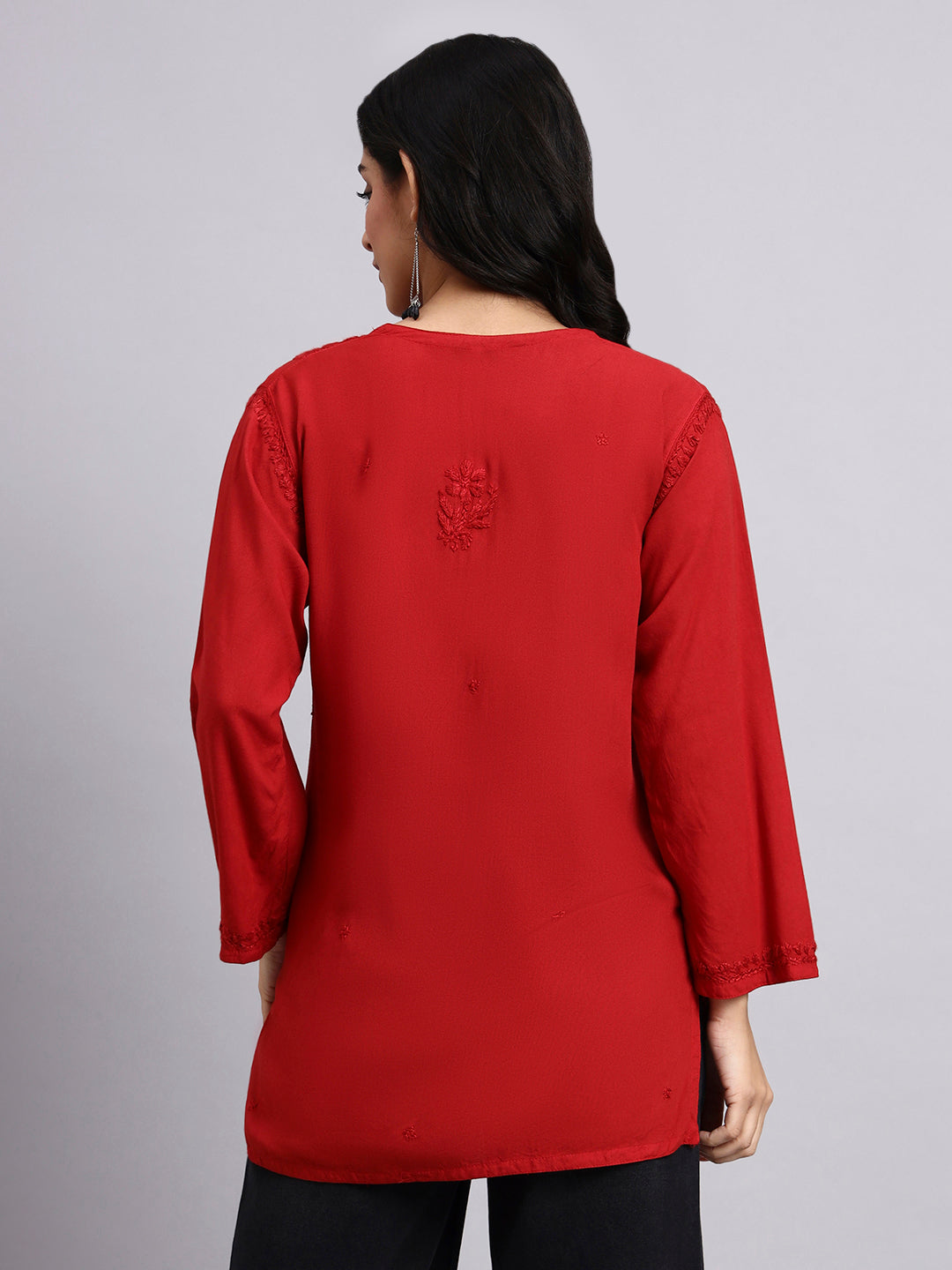 Back view of Red long-sleeve top worn by a person on a gray background