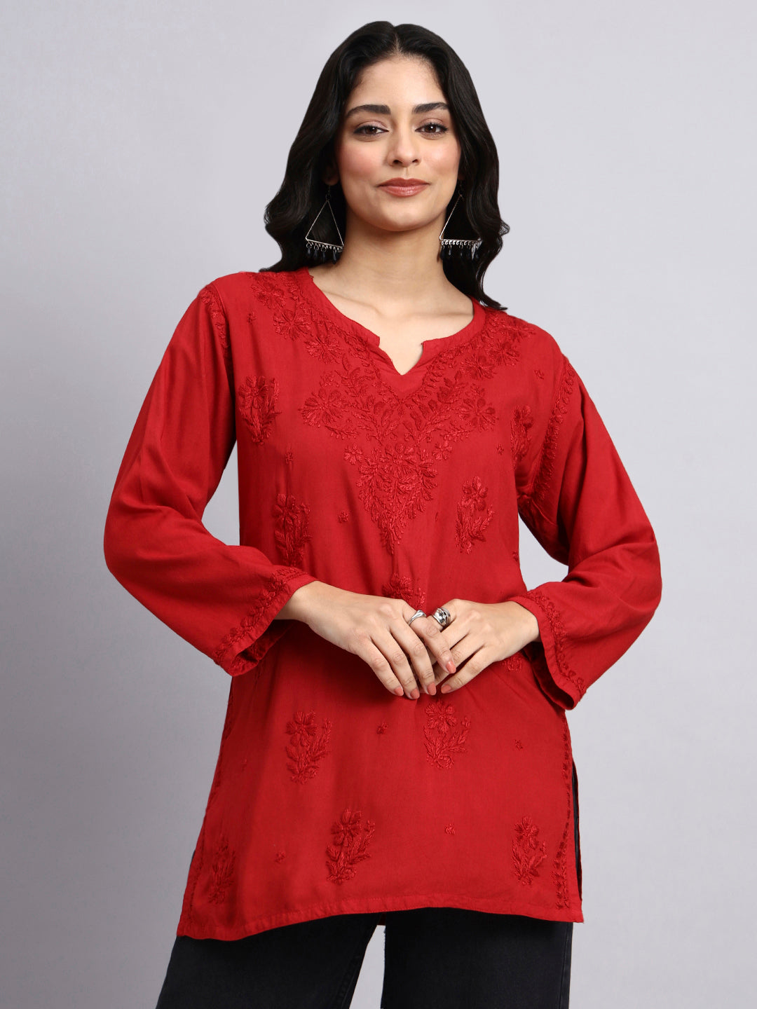 Woman wearing a red embroidered chikankari kurta against a gray background