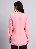 Back view of Woman wearing a pink long-sleeve chikankari kurtaon a gray background
