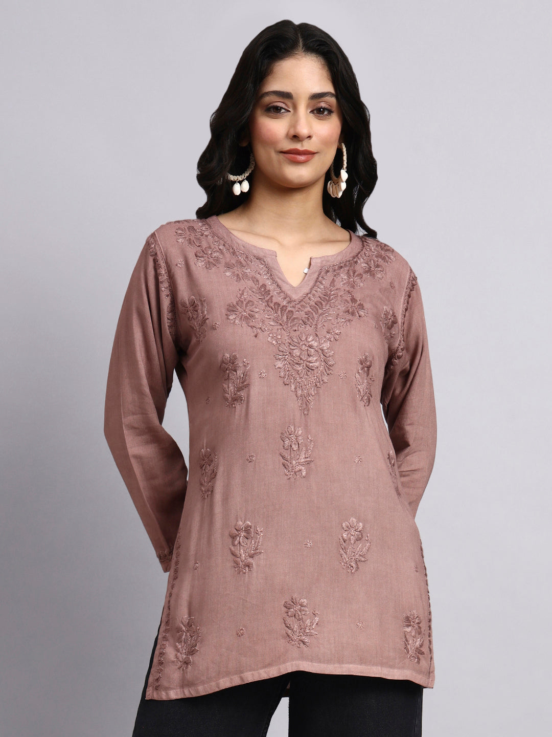 Woman wearing a mauve embroidered chikankari short kurta against a gray background