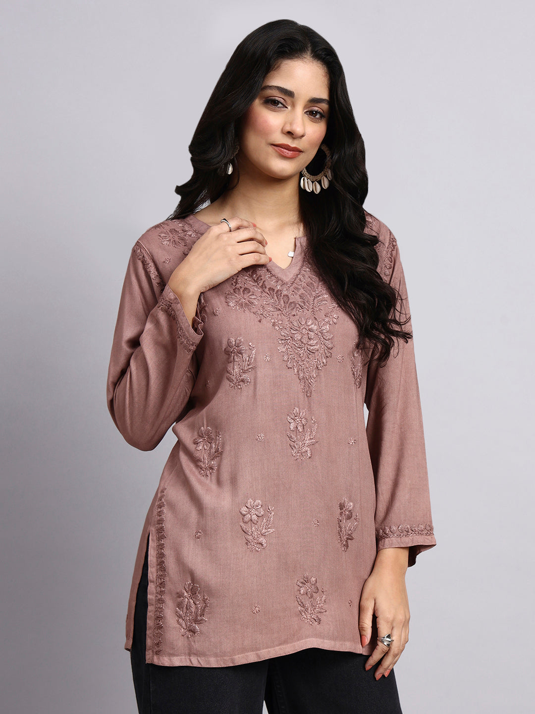 Woman wearing a mauve embroidered kurta against a plain background