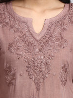 Close-up of a mauve blouse with intricate floral embroidery