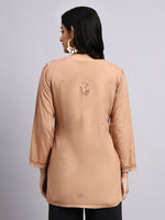 Back View of Woman wearing a beige long-sleeve kurta on a gray background