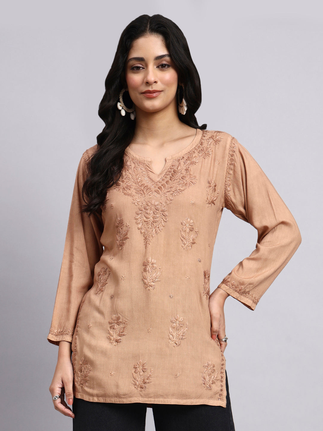 Front View of Woman wearing a beige embroidered Chikankari Kurta against a gray background