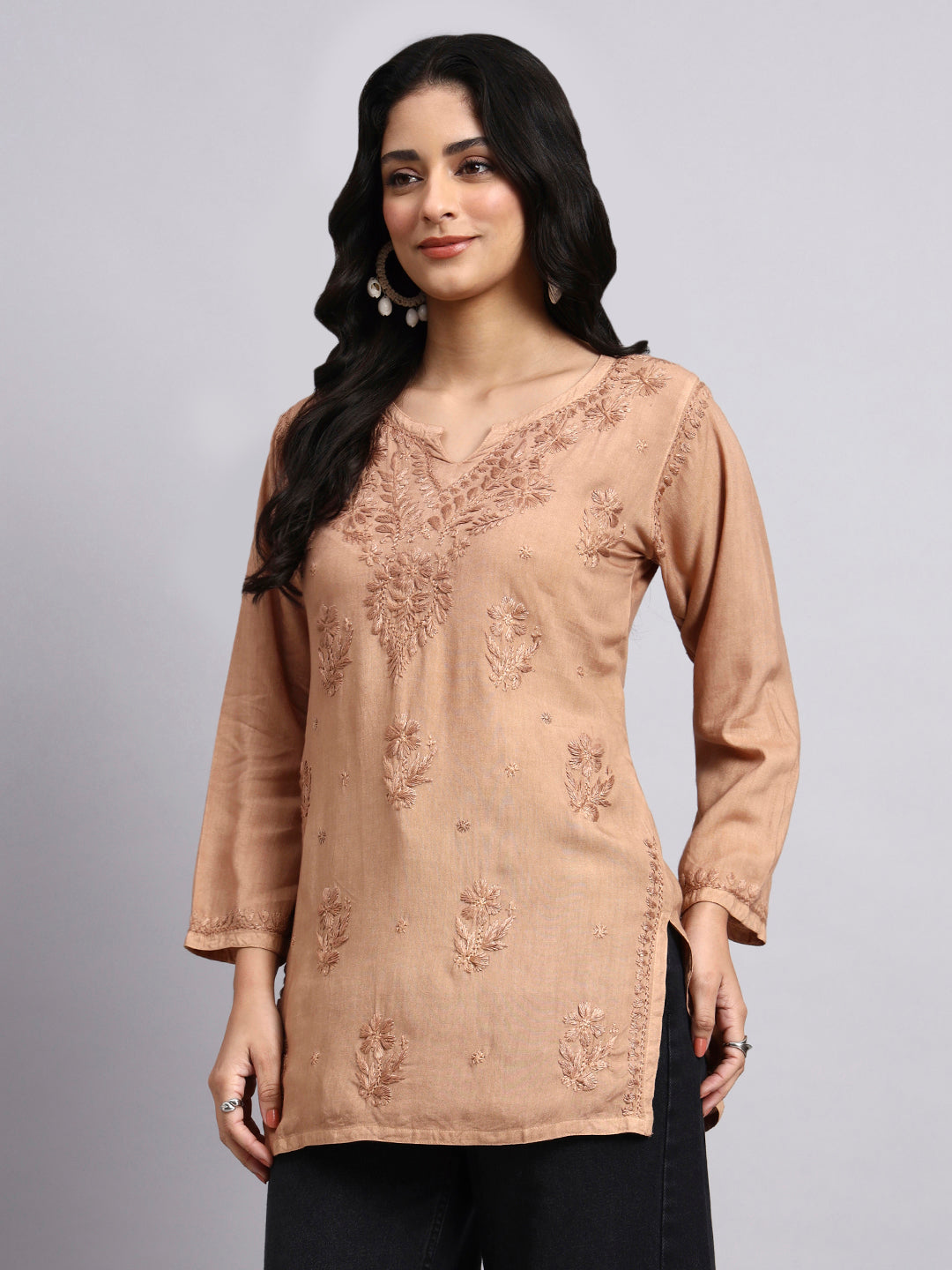 Woman wearing a beige Chikankari Short Kurta against a gray background