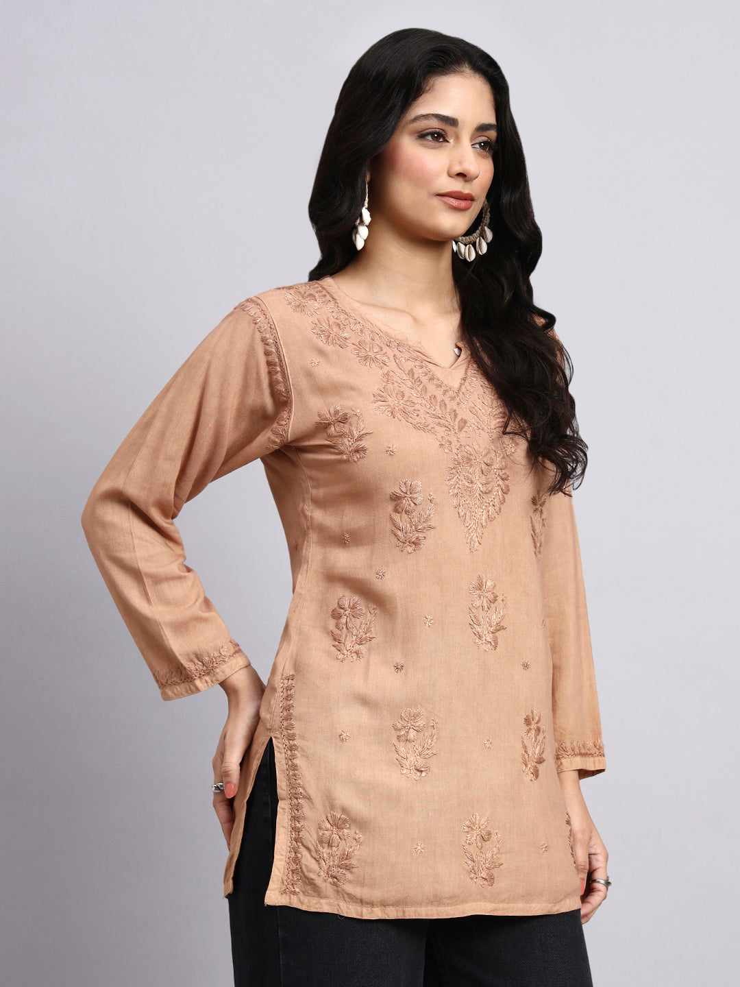 Side View of Woman wearing a beige Chikankari top against a gray background